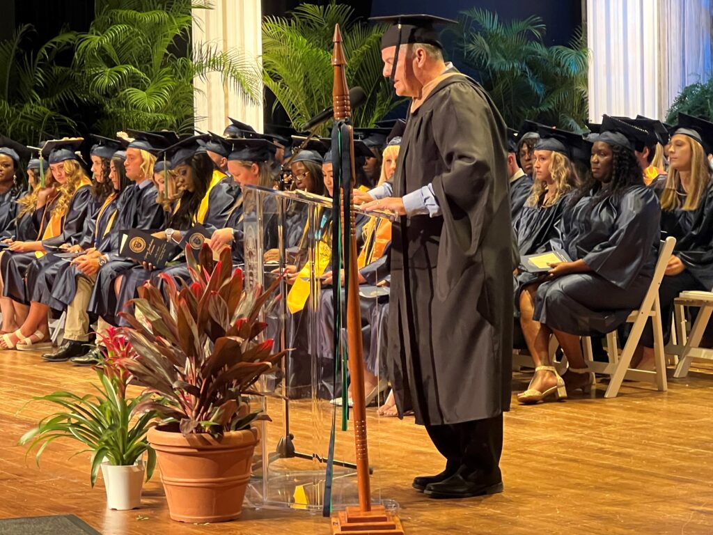 Dr. Todd G. Fritch (at podium), executive vice president and provost, presents the graduates during Friday’s commencement ceremony.